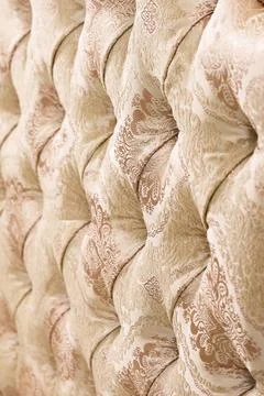 Beige soft tapestry pattern background with symmetrical buttons on the cor... Stock Photos