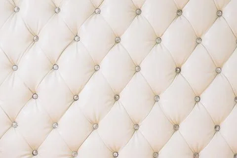 Beige soft tapestry pattern background with symmetrical buttons on the cor... Stock Photos