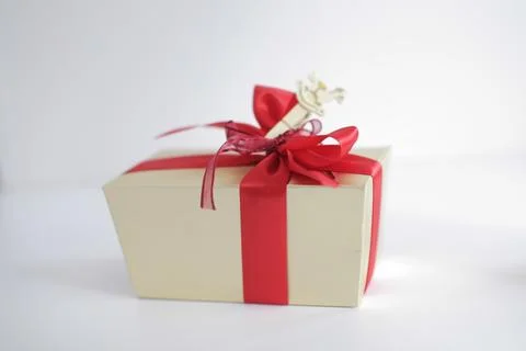 Beige square gift box with red bow on white background Stock Photos