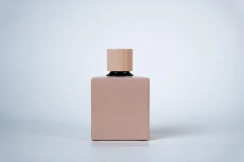Beige square perfume bottle on light background Stock Photos