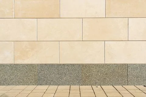 Beige Stone Facade Wall with Gray Granite Base and Paved Walkway Stock Photos