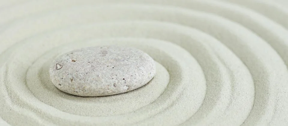 Beige stone on sand with pattern lines, zen garden,meditation, harmony. Banner. Stock Photos