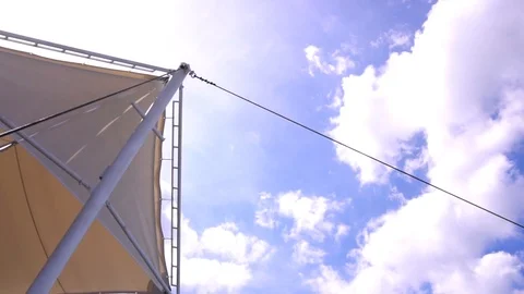 Beige stretch tent in summer sun rays on clear blue sky background Vídeo Stock 88553547