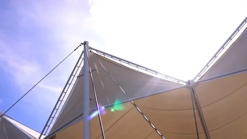 Beige stretch tent in summer sun rays on clear blue sky background Stock-Footage 88556777