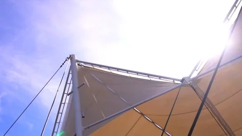 Beige stretch tent in summer sun rays on clear blue sky background Stock-Footage 88556799