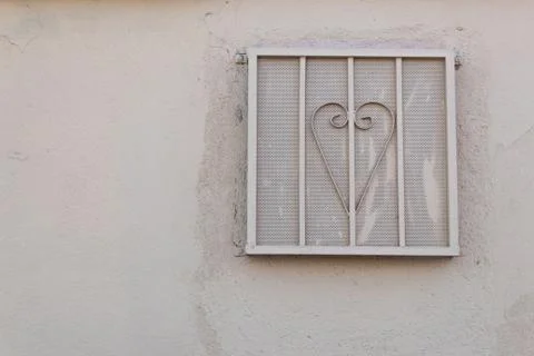 Beige stucco wall with attached security and ventilation screen Stock Photos