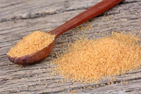 Beige sugar in a spoon and table Stock Photos