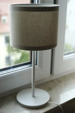 Beige table lamp on window cozy modern interior Stock Photos