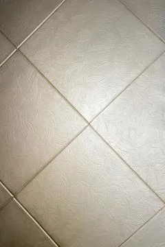 Beige textured ceramic tiles with a subtle leaf pattern for modern interior Stock Photos