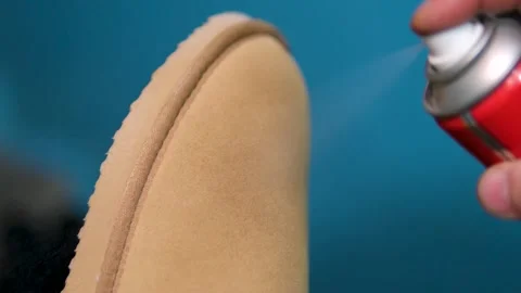 Beige ugg boots Applying a water-repellent hydrophobic spray to white women's Stock-Footage 302072236