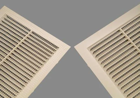 Beige ventilation grate on a gray background. Square shape, plastic material. Stock Photos