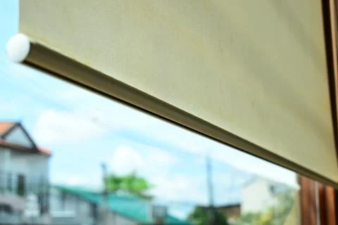 Beige window roller shade bar with blurred outdoor city view Stock Photos