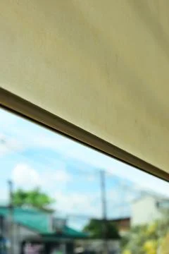 Beige window roller shade bar with blurred outdoor city view Stock Photos