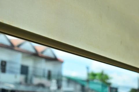 Beige window roller shade bar with blurred outdoor city view Stock Photos