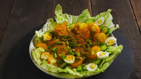 Beijing cabbage salad with yellow tomatoes, cucumbers and quail eggs sprinkled w Stock Footage 229800359