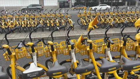 BEIJING, CHINA - 2026/02/28: Two rows of yellow shared bicycles on sidewalk. Stock Footage 330033563