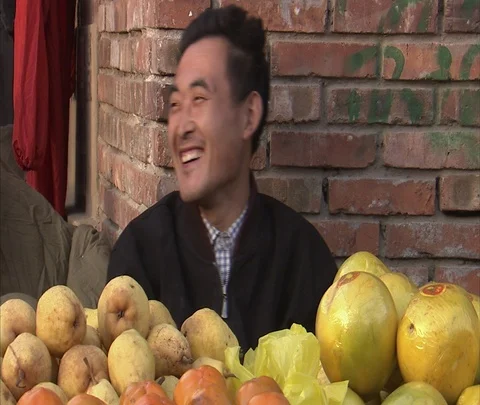 Beijing, China; MS Man at fruit stand laughing; selling fruit Stock Footage 86745502