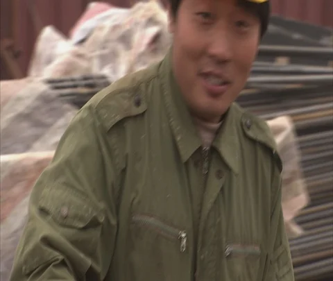 Beijing, China; Smiling worker in hard hat picks up rebar Video stock 86744271