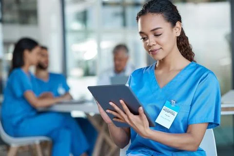 Being able to view documents on the go. a young female nurse using a digital Fotos Stock