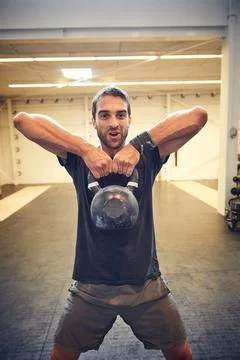 Being average is a waste of time. a handsome young man working out with a kettle Stock Photos
