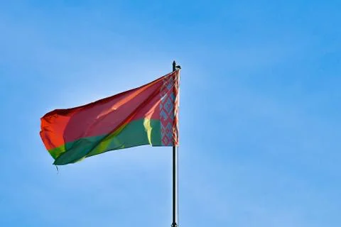 Belarusian flag on sky background. Develops in the wind. Flag of Belarus. Stock Photos