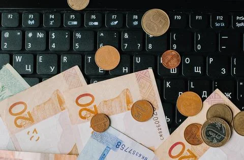 Belarussian banknotes and coins on the computer keyboard. Remote work, freela Stock-Fotos