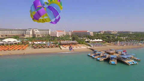 Belek, Turkey - September 27, 2023: Happy couple flying on a parachute Stock Footage 252133839