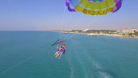 Belek, Turkey - September 27, 2023: Happy couple flying on a parachute Stock Footage 252135646