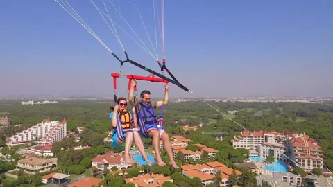 Belek, Turkey - September 27, 2023: Happy couple flying on a parachute Stock Footage 252139601