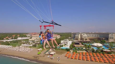 Belek, Turkey - September 27, 2023: Happy couple flying on a parachute Stock Footage 252145485