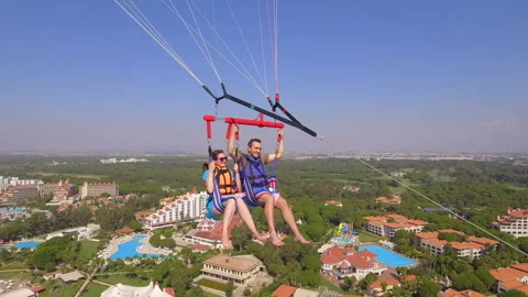 Belek, Turkey - September 27, 2023: Happy couple flying on a parachute Stock Footage 252145668