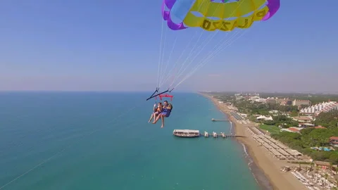 Belek, Turkey - September 27, 2023: Happy couple flying on a parachute Stock Footage 252151089