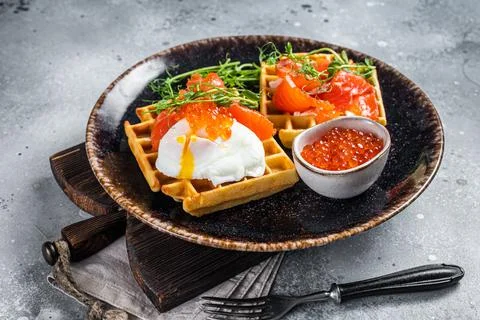 Belgian waffle with cream cheese, salmon slices, egg and red caviar. Gray Stock Photos