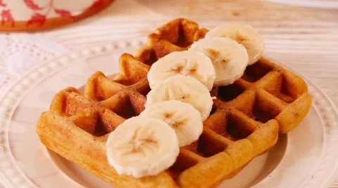 Belgian waffles with chocolate chips sprinkled arm, a broken tile, banana Stock Footage 62191726