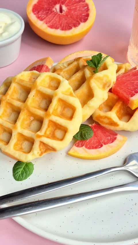 Belgian waffles with grapefruit on a white plate Stock Footage 304873485