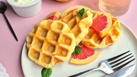 Belgian waffles with grapefruit on a white plate Stock Footage 304873486