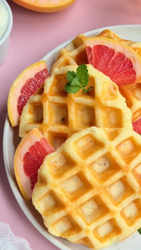 Belgian waffles with grapefruit on a white plate Stock Footage 304873490