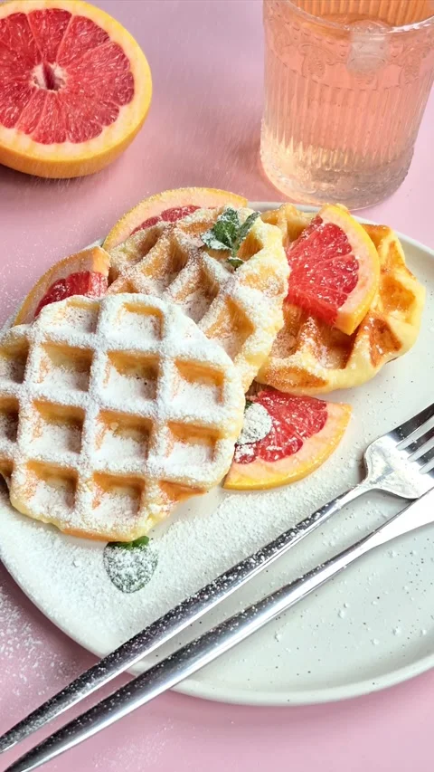 Belgian waffles with grapefruit on a white plate Stock Footage 304873492