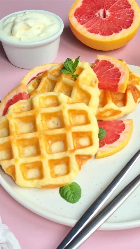 Belgian waffles with grapefruit on a white plate Stock Footage 304873804