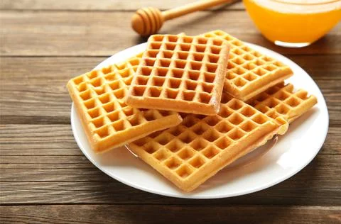 Belgian waffles on grey background. Belgian waffles with honey. Freshly baked Stock Photos