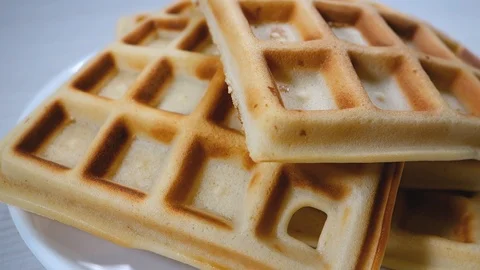 Belgian waffles in a white plate on a light wooden background. Waffles without Stock Footage 119601459