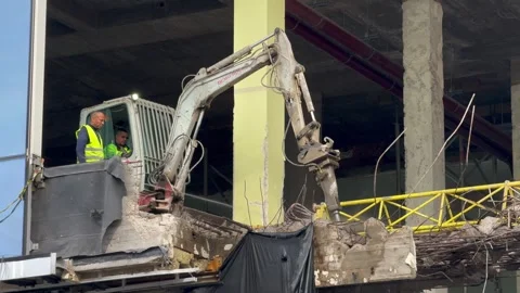 Belgium - October 14, 2024; A machine run by men demolishing a building Stock Footage 297406831