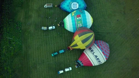 BELGOROD - AUG 4: Balloons fly up in sky with passengers over green field Video stock 93396822