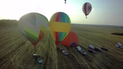 BELGOROD - AUG 5: Balloons fly up in sky with passengers over green field, on Stock-Footage 87985222