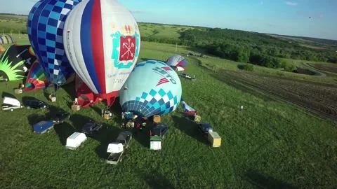 BELGOROD - AUG 5: Balloons fly up in sky with passengers over green field, on Stock Footage 88704699