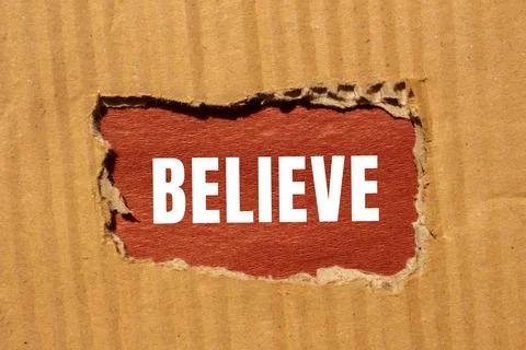 Believe message written on ripped torn paper background. Conceptual Believe.. Foto stock