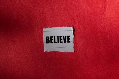 Believe message written on ripped torn paper background. Conceptual Believe.. Foto stock
