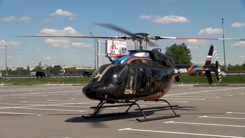 Bell 407 helicopter with rotating main rotor blades in the parking lot. Stock Footage 106553325