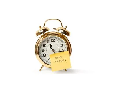 A bell alarm clock with a sticky note with don  t forget short phrase Stock Photos
