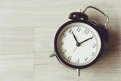 Bell clock old retro style at wooden background with copy space for text, h.. Stock Photos